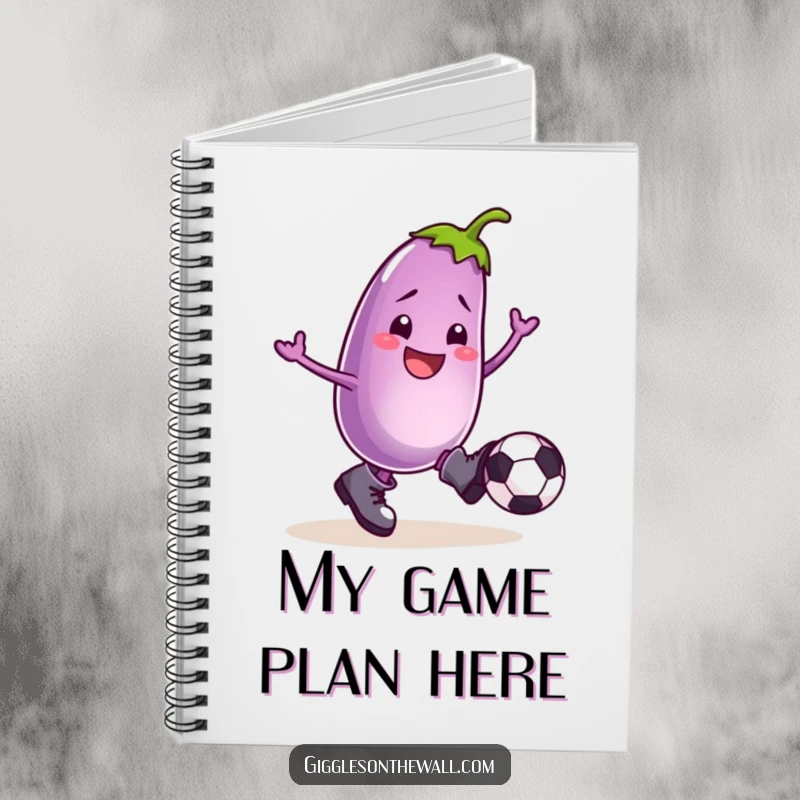 Funny notebook with a smiling eggplant in boots, kicking a football, ideal for jotting down notes with comedic inspiration.