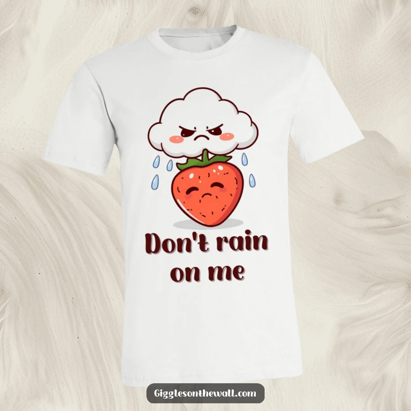 Funny t-shirt depicting a grumpy cloud raining on a sunbathing strawberry, embodying a playful contrast of moods.