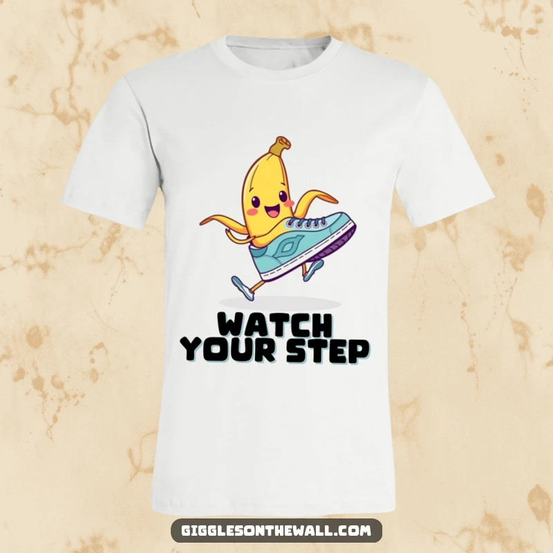 Funny t-shirt showing a smiling banana peel attempting to trip a running shoe, perfect for prank lovers.