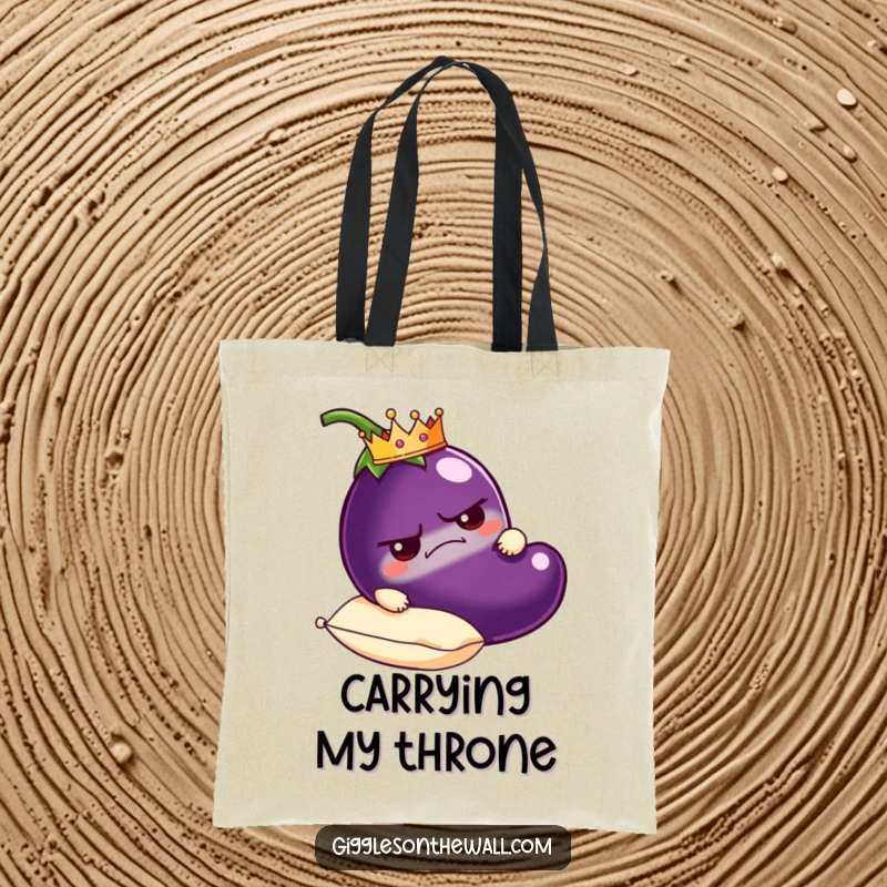 Funny grumpy eggplant tote bag wearing a tiny crown, carried on a plush pillow, a humorous and stylish accessory.